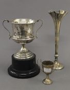 A silver bud vase, a small silver trophy cup and a broken silver trophy cup. The former 22 cm high.