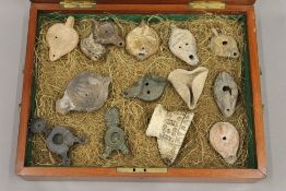 A collection of antiquity and later oil lamps, housed in mahogany box. The box 47 cm wide.