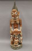 A painted carved wooden Yoruba maternity figure. 84.5 cm high.