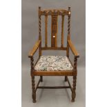 An early 20th century oak barley twist open armchair. 56 cm wide.