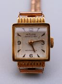 A ladies 18 ct gold Mithra wristwatch with a roll gold strap, 17 jewel Swiss movement.
