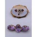 A Victorian garnet and seed pearl set brooch and an amethyst set brooch. The former 4.25 cm wide.