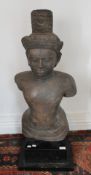 A life size torso South Asian stone figure of Shiva, mounted on a display plinth.