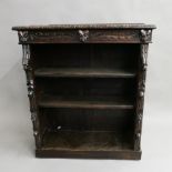 A Victorian carved oak bookcase. 91 cm wide.