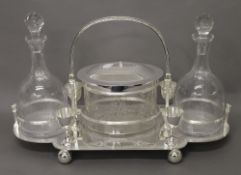 A silver plated biscuit jar and decanter set. 47 cm wide.