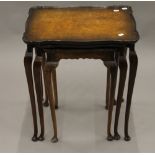 A nest of three walnut tables. 50.5 cm wide.