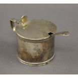 A silver mustard pot with blue glass liner and a silver spoon. 6 cm high. 3.9 troy ounces.