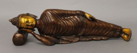 A bronze figure of a reclining Buddha. 33 cm long.