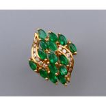 A 14 ct gold, diamond and emerald ring. Ring size L/M. 7.4 grammes total weight.