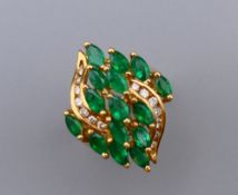 A 14 ct gold, diamond and emerald ring. Ring size L/M. 7.4 grammes total weight.
