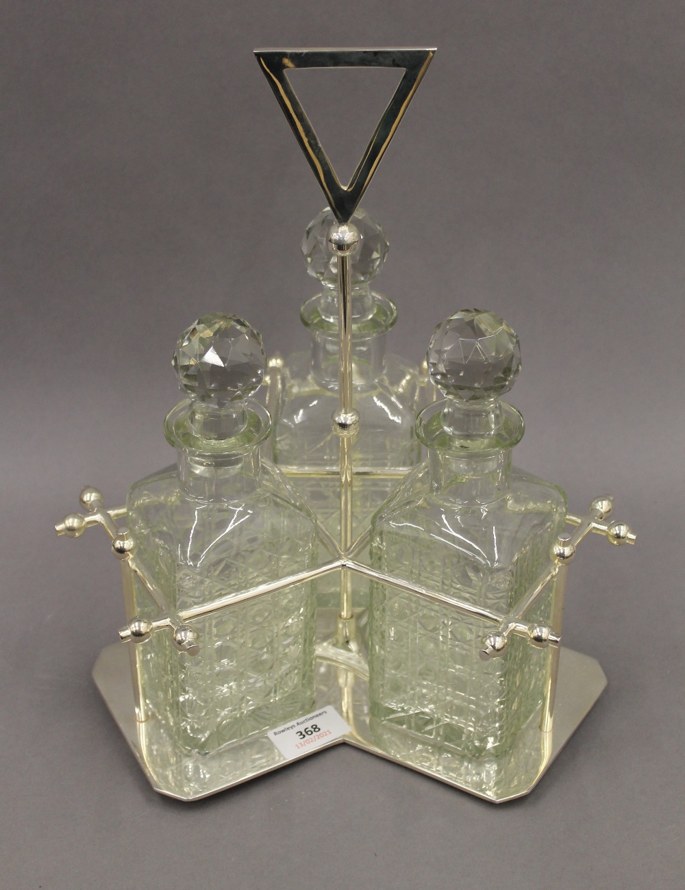A silver plated three bottle decanter stand. 34 cm high.