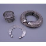 Three Eastern white metal bangles, two probably unmarked silver. The largest 12.5 cm diameter.