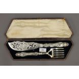 A cased pair of silver handled fish servers. The case 39 cm wide.