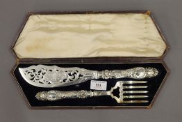 A cased pair of silver handled fish servers. The case 39 cm wide.