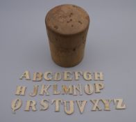 A quantity of 19th century bone alphabetic letters in turned wooden box.