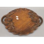 An Eastern carved wooden tray with floral decoration. 46.5 cm wide.