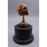 A 19th century memento mori bone skull, mounted on a display plinth. 8.5 cm high overall.