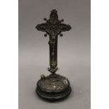 A Continental plated crucifix on ebonised stand. 23.5 cm high overall.
