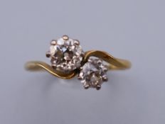 An 18 ct gold and platinum diamond crossover ring. Ring size P. 2.5 grammes total weight.