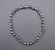 A string of grey pearls. 43 cm long.