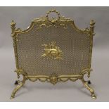 An ornate brass fire guard. 65 cm wide.