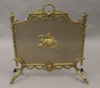 An ornate brass fire guard. 65 cm wide.