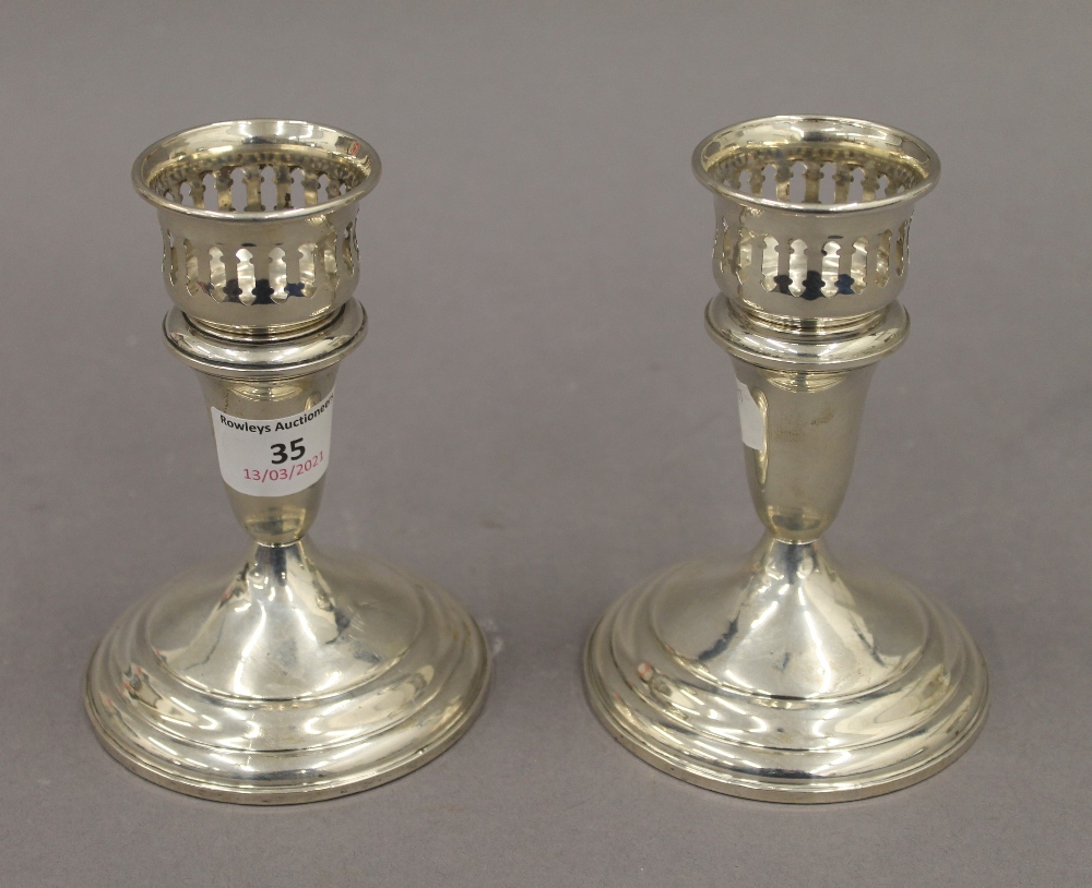 A pair of sterling silver candlesticks with detachable sconces. 13 cm high. 23.4 troy ounces loaded.