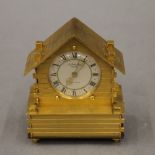 A brass cased Swiss desk clock formed as a Chalet. 11 cm high.