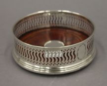 A hallmarked silver and wood based coaster. 12.5 cm diameter.