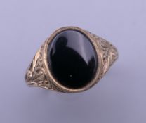 A 9 ct gold and onyx gentleman's signet ring. Ring size V.