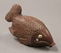 A Japanese model of a fish enclosing a compass and a magnifying glass. 13 cm long.