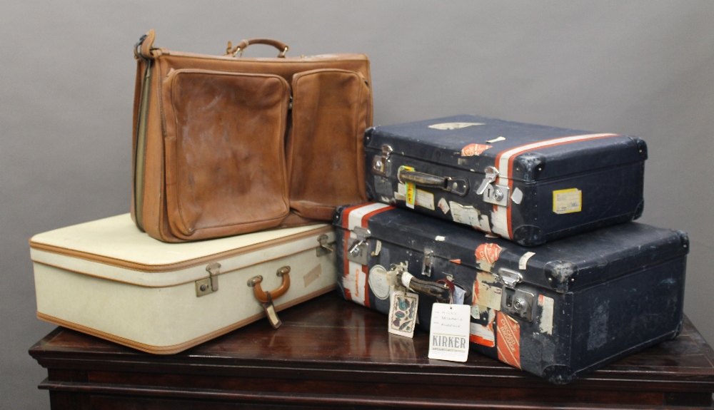 A leather travelling bag and two vintage suitcases