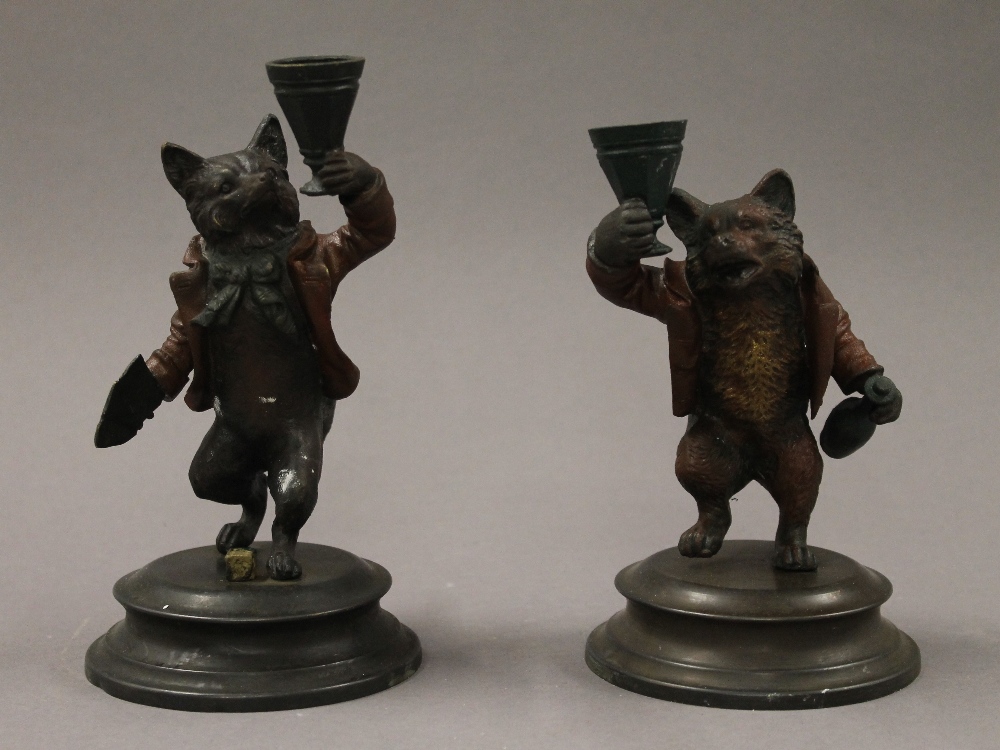 A pair of painted bronze fox form candlesticks. 16 cm high.