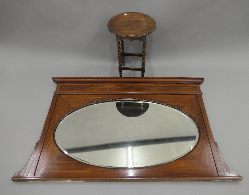 An Edwardian mahogany overmantle mirror and a small oak barley twist side table.