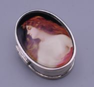 An oval silver pill box depicting a girl. 2.5 cm wide.