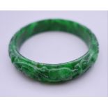 A carved apple green jade bangle. Exterior 7 cm diameter.