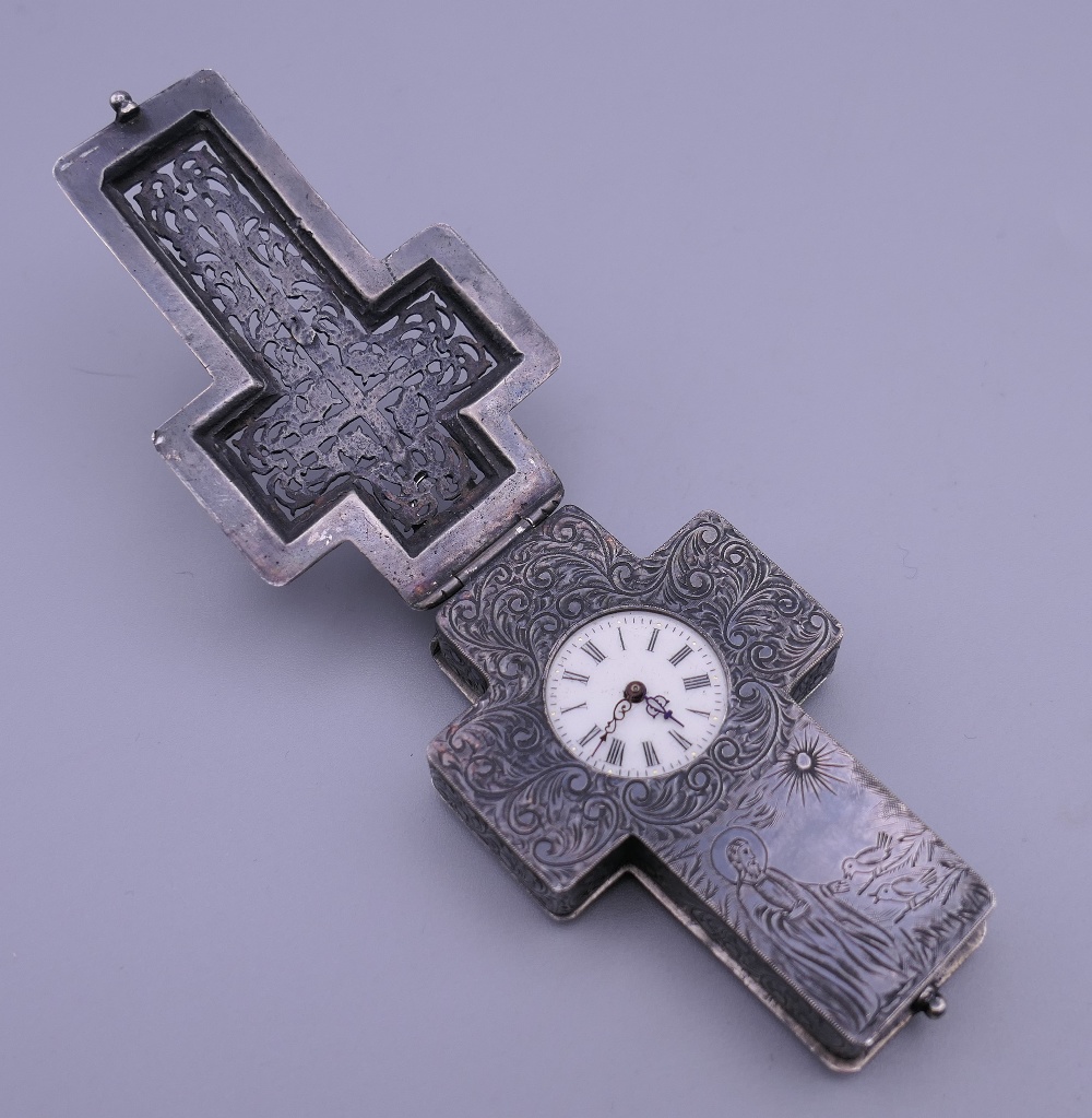 A 19th century unmarked white metal cross form pendant watch. 8 cm high.
