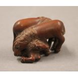 A Japanese carved wood netsuke in the form of horses. 4.5 cm long.