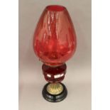 A Victorian oil lamp with ruby glass reservoir and cranberry glass shade. 63 cm high.