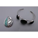 A silver and three stone onyx Navajo bangle and a Navajo silver and turquoise pendant with musician