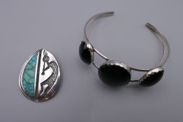 A silver and three stone onyx Navajo bangle and a Navajo silver and turquoise pendant with musician