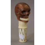 A wood and bone skull walking stick top. 14 cm high.