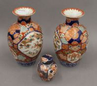 A pair of 19th century Japanese Imari decorated vases together with an Imari tea caddy.