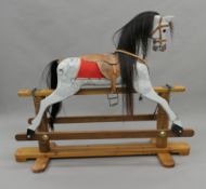 A 20th century painted wooden child's rocking horse. 137 cm long.