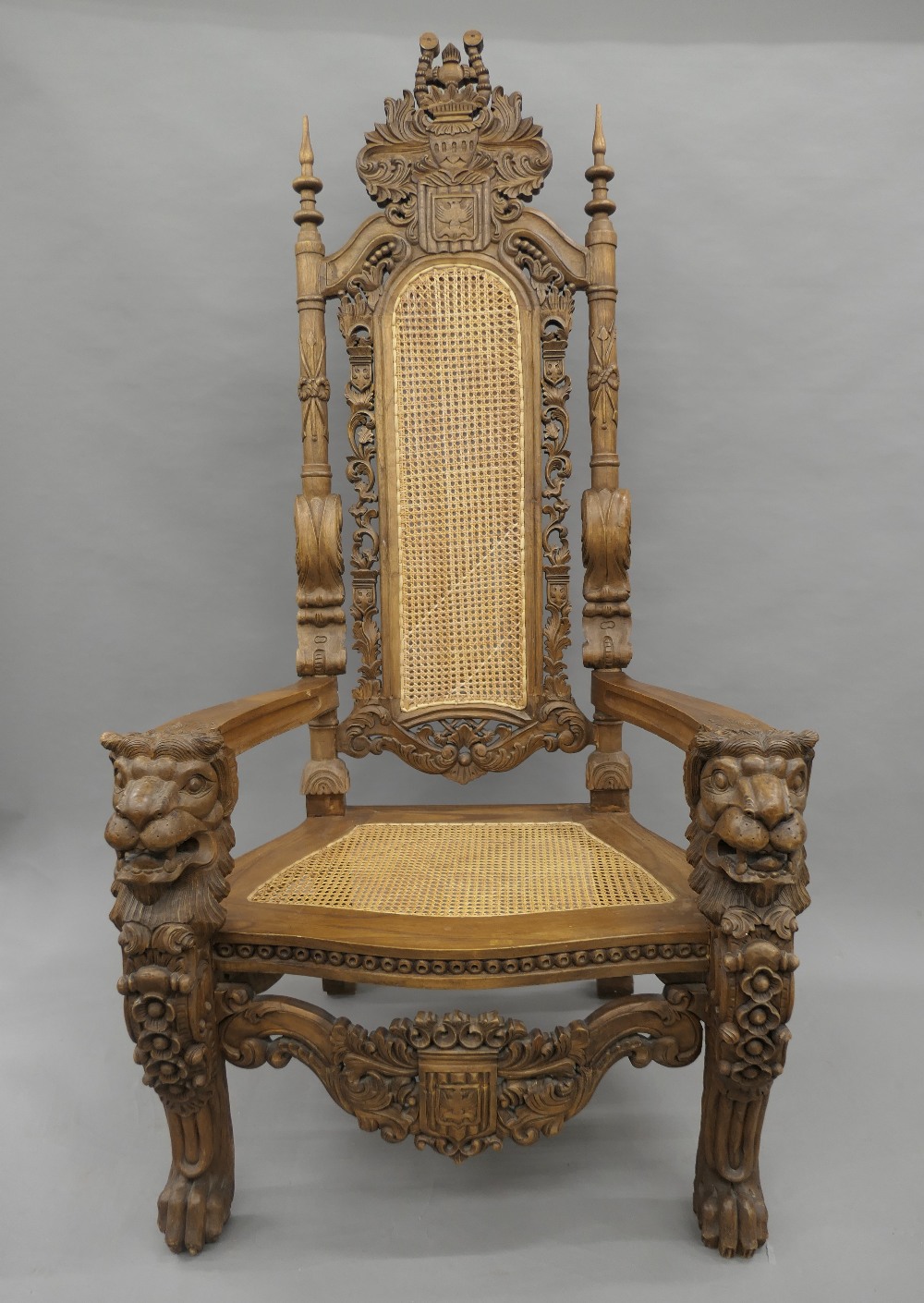 A large Eastern, possibly Indonesian, carved and caned open armchair. 94 cm wide x 180 cm high.