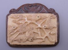 A Chinese bone and wood plaque. 6 cm wide.