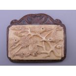 A Chinese bone and wood plaque. 6 cm wide.