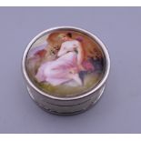 A silver circular pill box depicting a girl. 2.5 cm diameter.