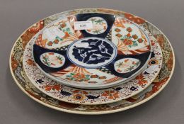 A Satsuma plate, two Imari plates and an Ironstone plate. The former 31 cm diameter.