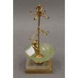 A gilt metal jewellery stand formed as a bear and a cherub, set with a jade bowl. 17 cm high.